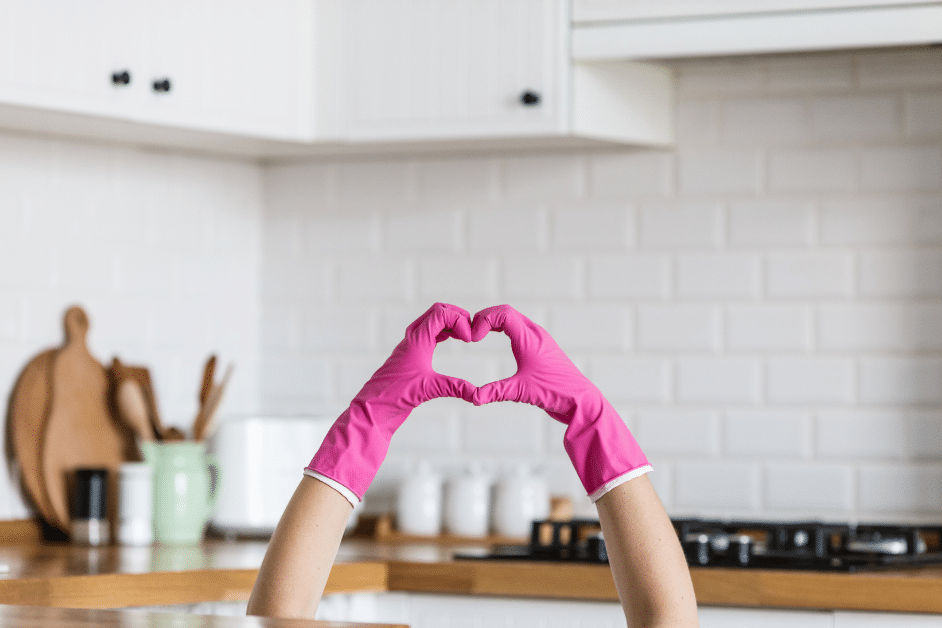 Image of gloved hands in kitchen making a heart sign